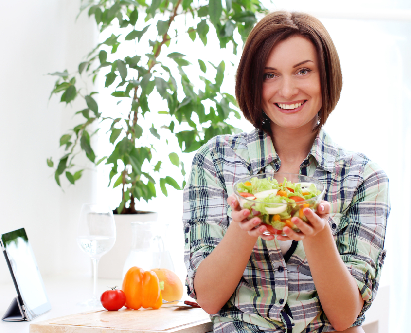Happy woman with bowl of fresh salad
